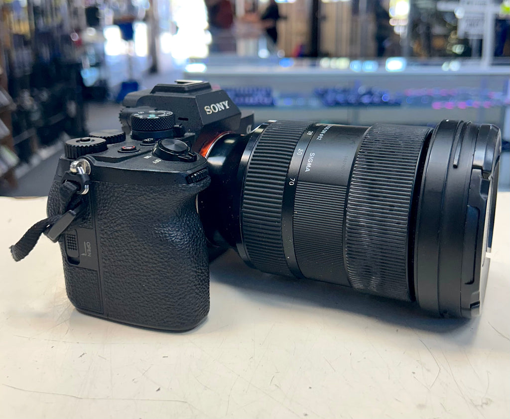 Sony A7 with camera with Sigma telephoto lens on a table in a store setting