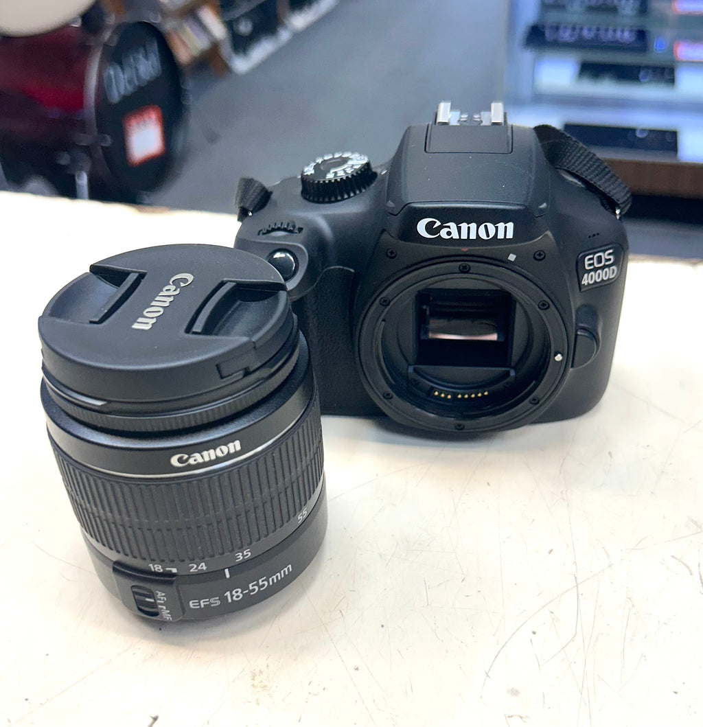 Canon EOS 4000D camera with lens on a light surface