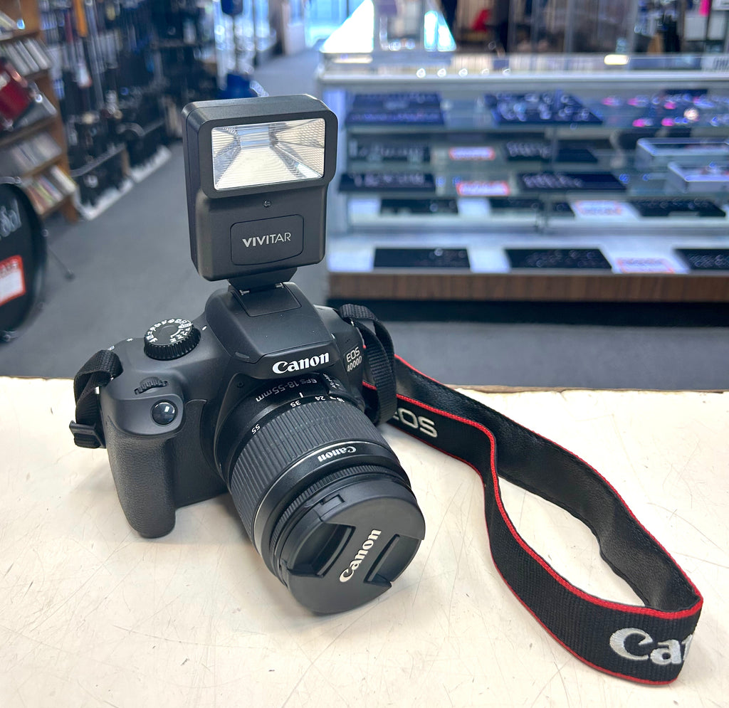 Canon camera with flash and strap on a counter in a store