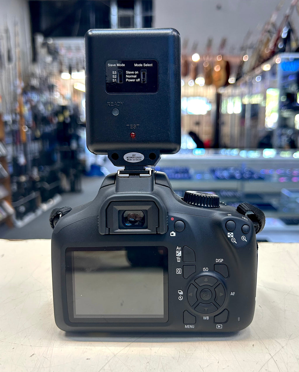 Camera body with flash attachment on a blurred store background