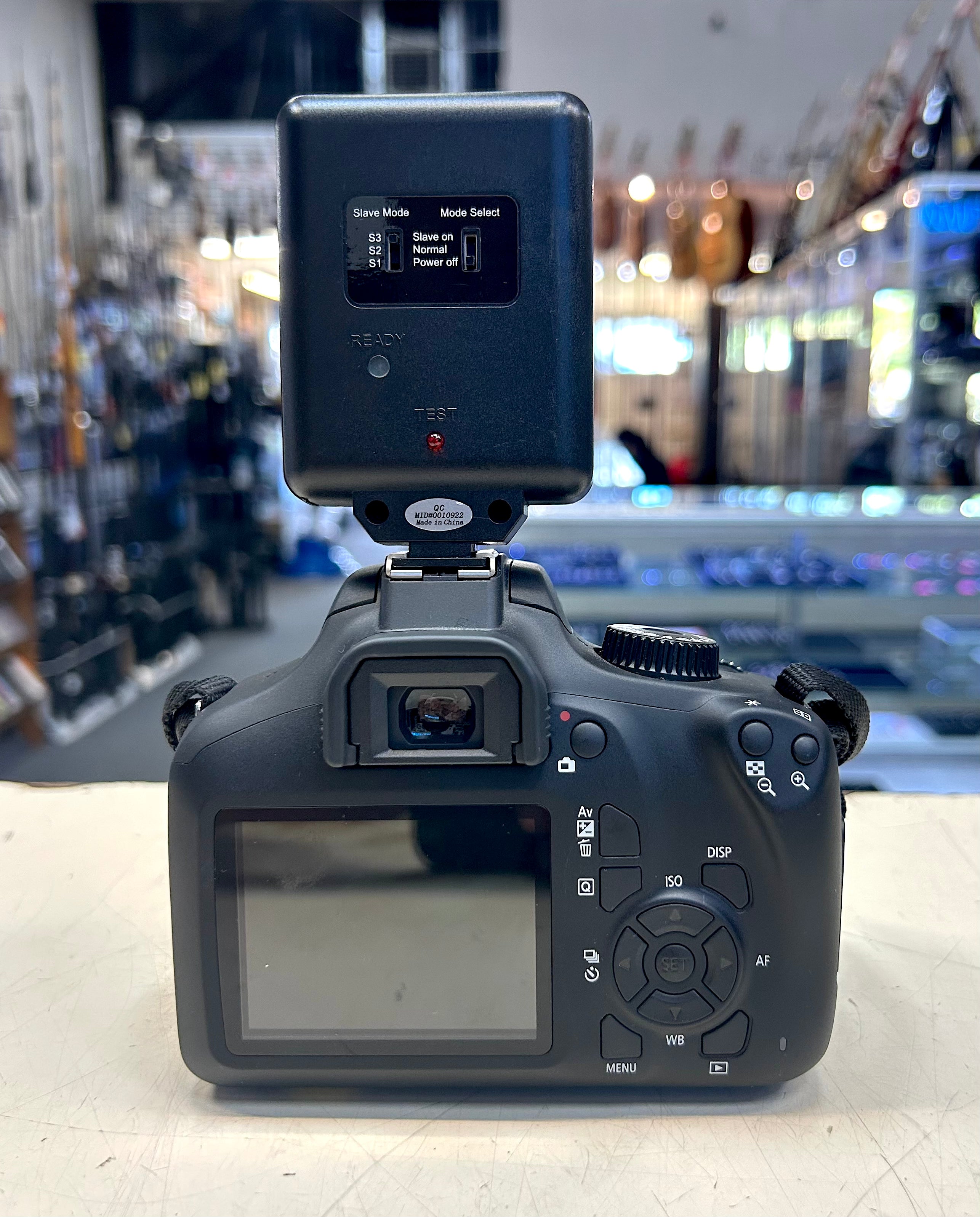 Camera body with flash attachment on a blurred store background