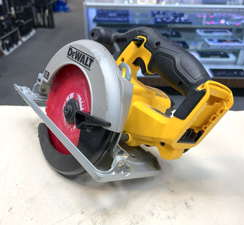 DeWalt circular saw on a white surface with a blurred workshop background