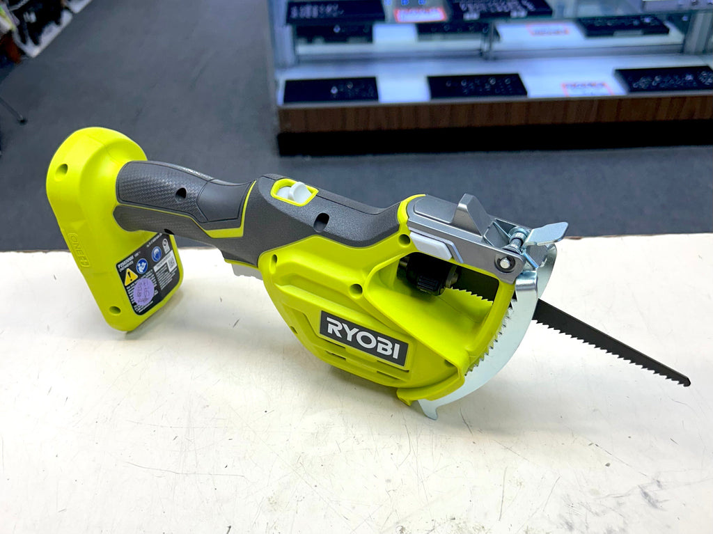 Ryobi power saw on a white surface with a blurred background