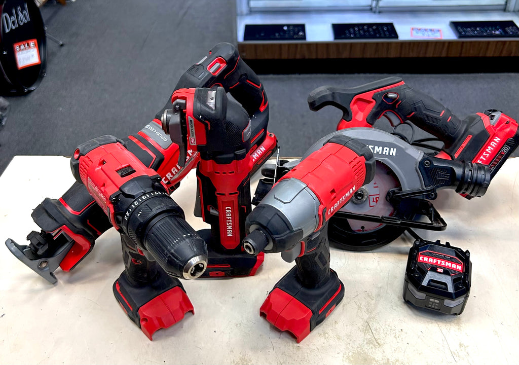 Set of red and black power tools on a white surface with a blurred background.