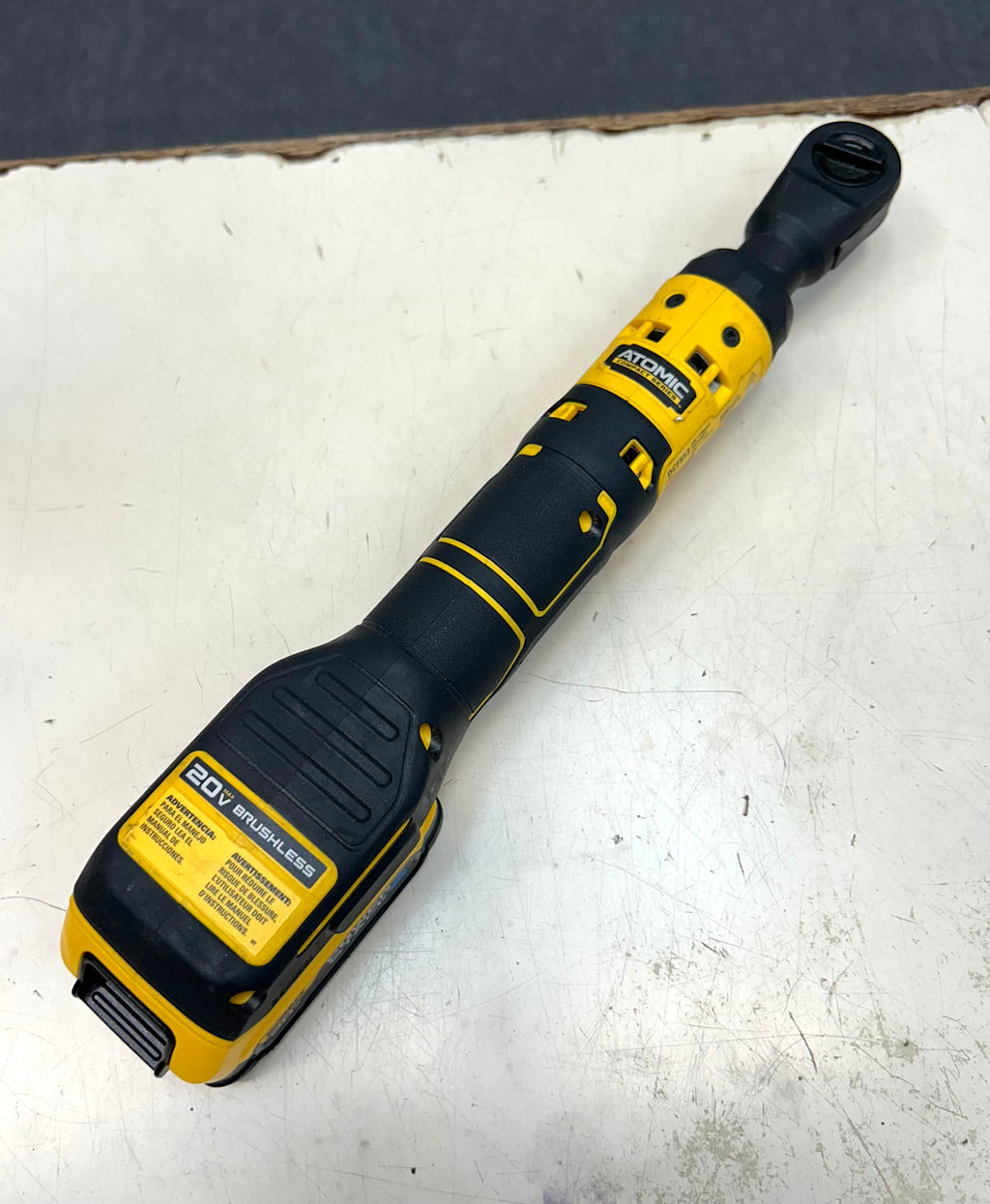 Yellow and black cordless drill on a white surface