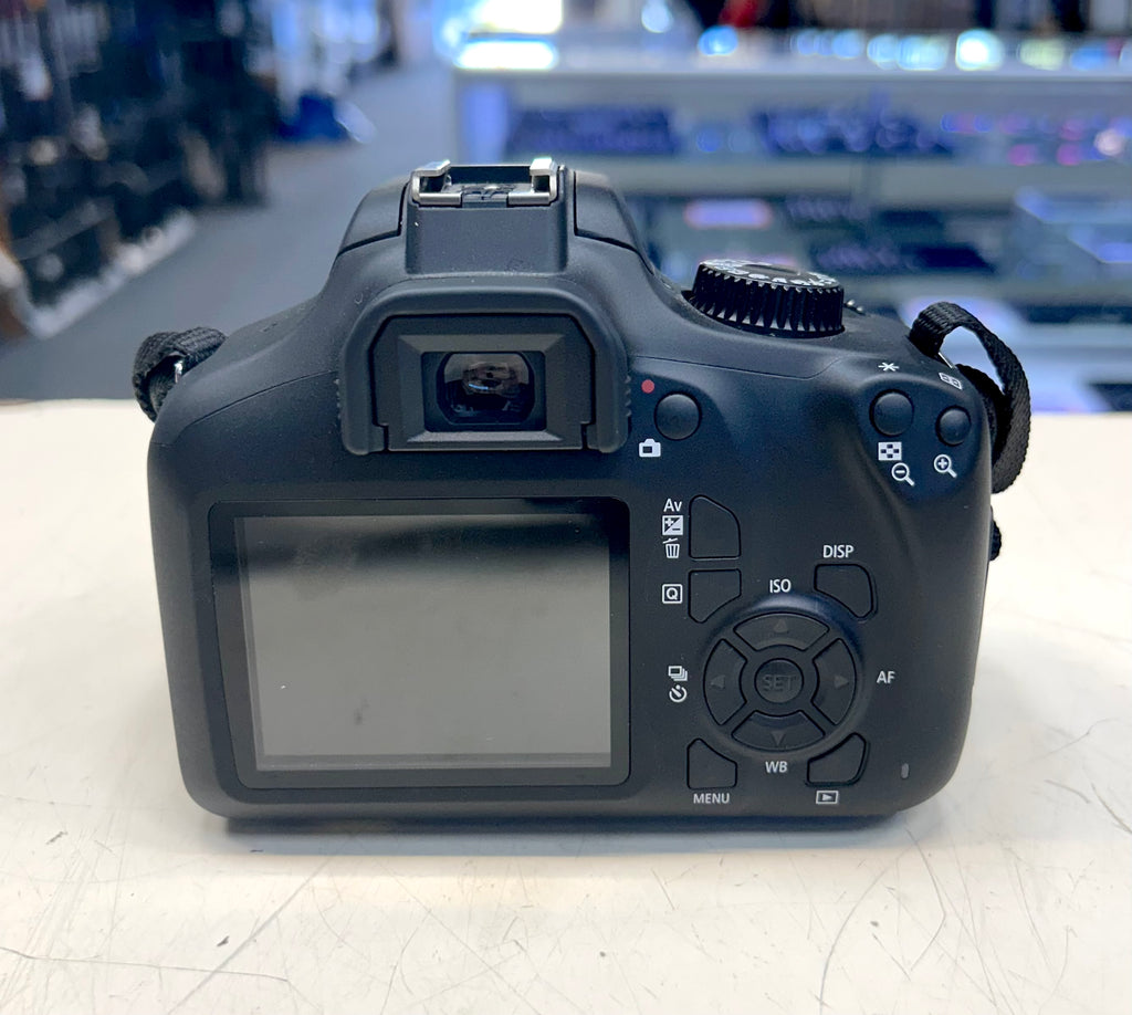 Black DSLR camera on a light surface with a blurred indoor background