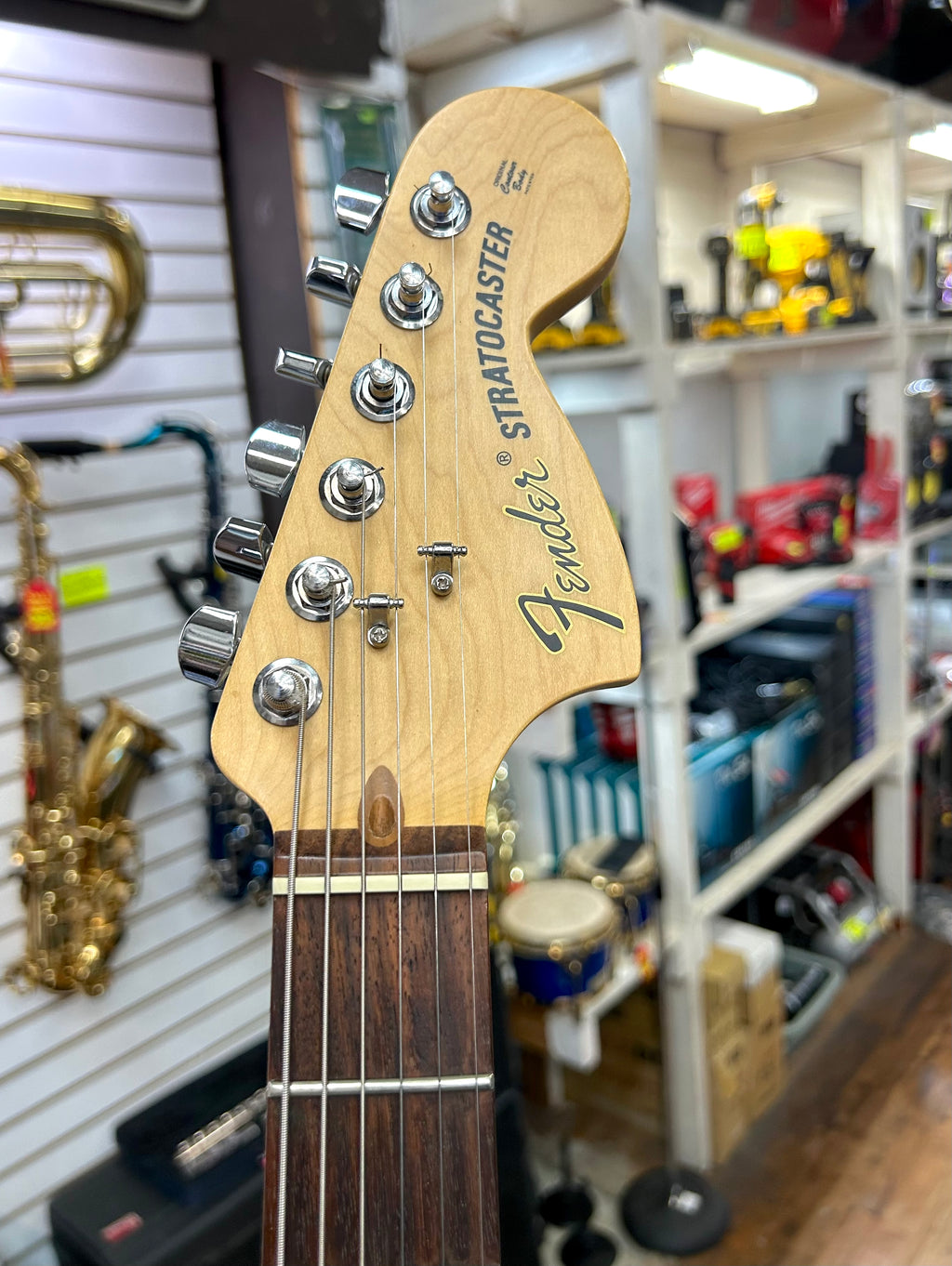 Fender Stratocaster guitar headstock in a music store setting
