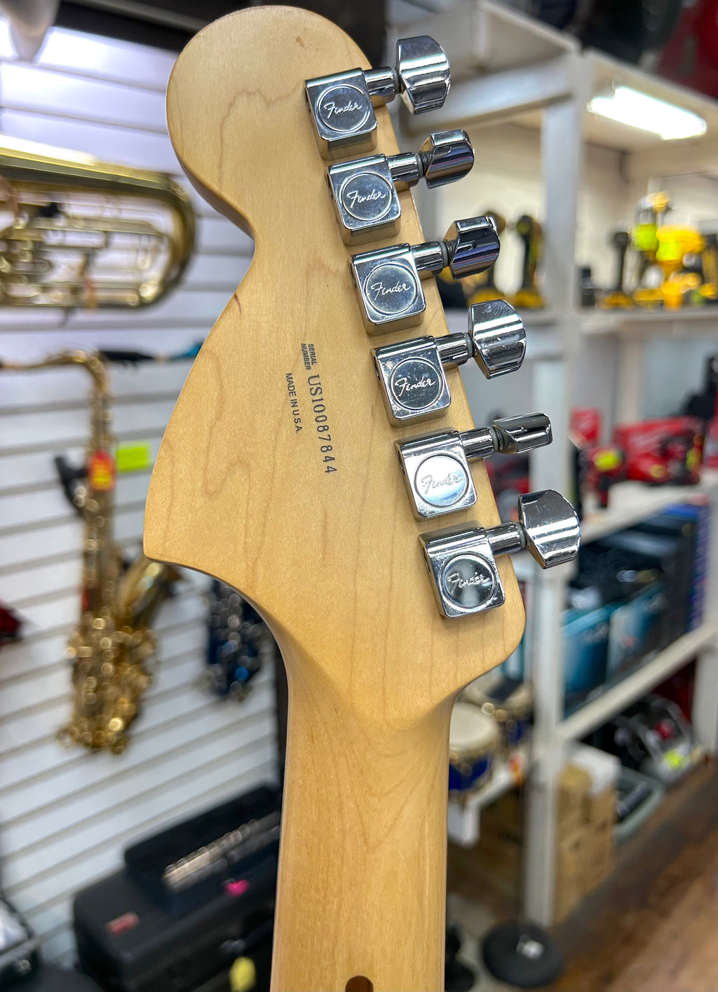 US made fender strat 
Guitar headstock with Fender tuning pegs in a music store setting