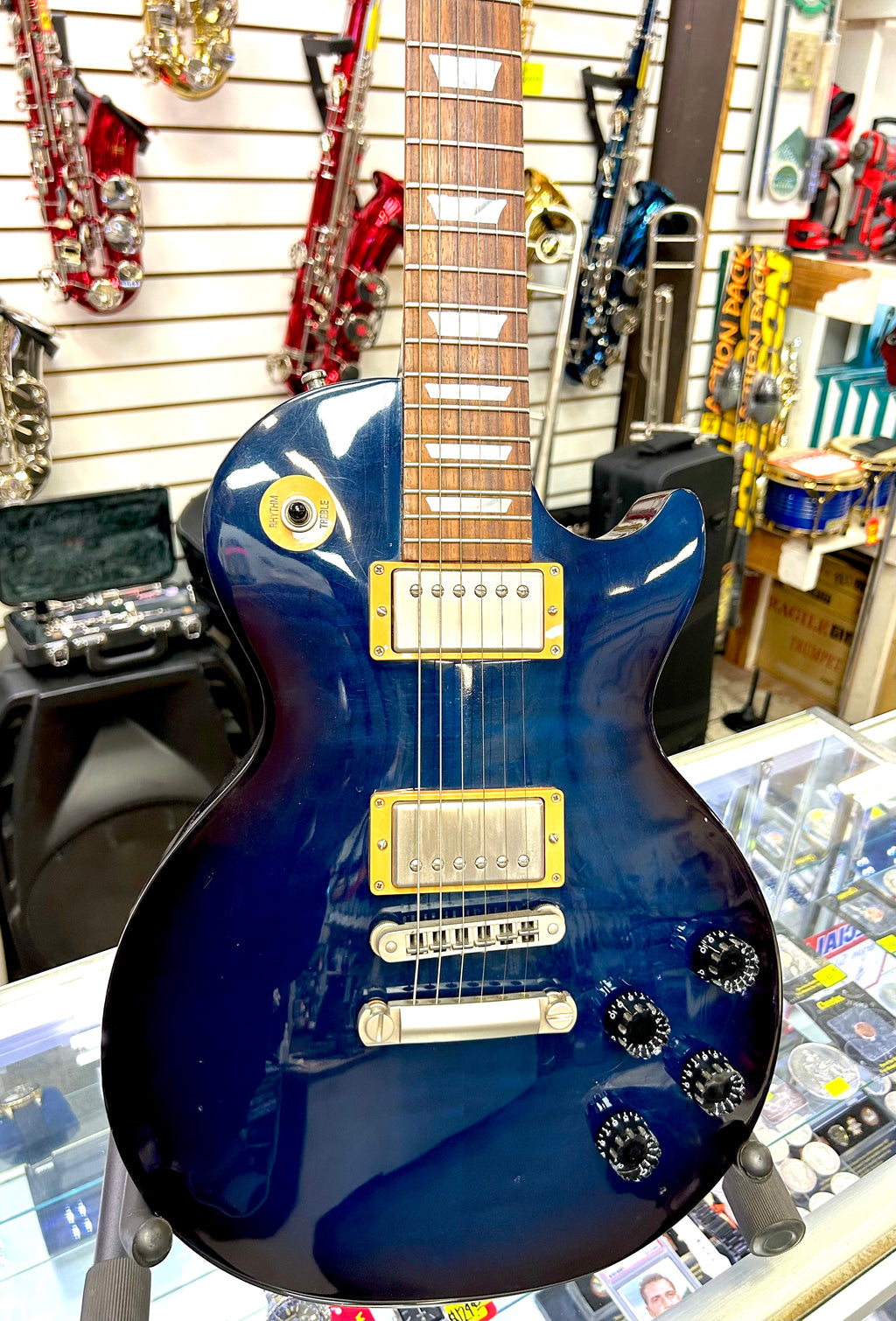 Blue Gibson Les Paul electric guitar with gold hardware on display in a store