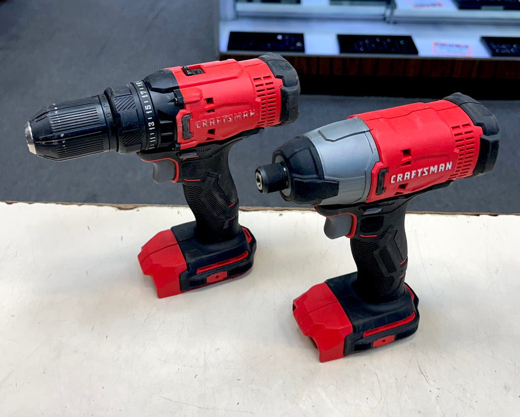 Two Craftsman cordless drills on a white surface with a blurred background.