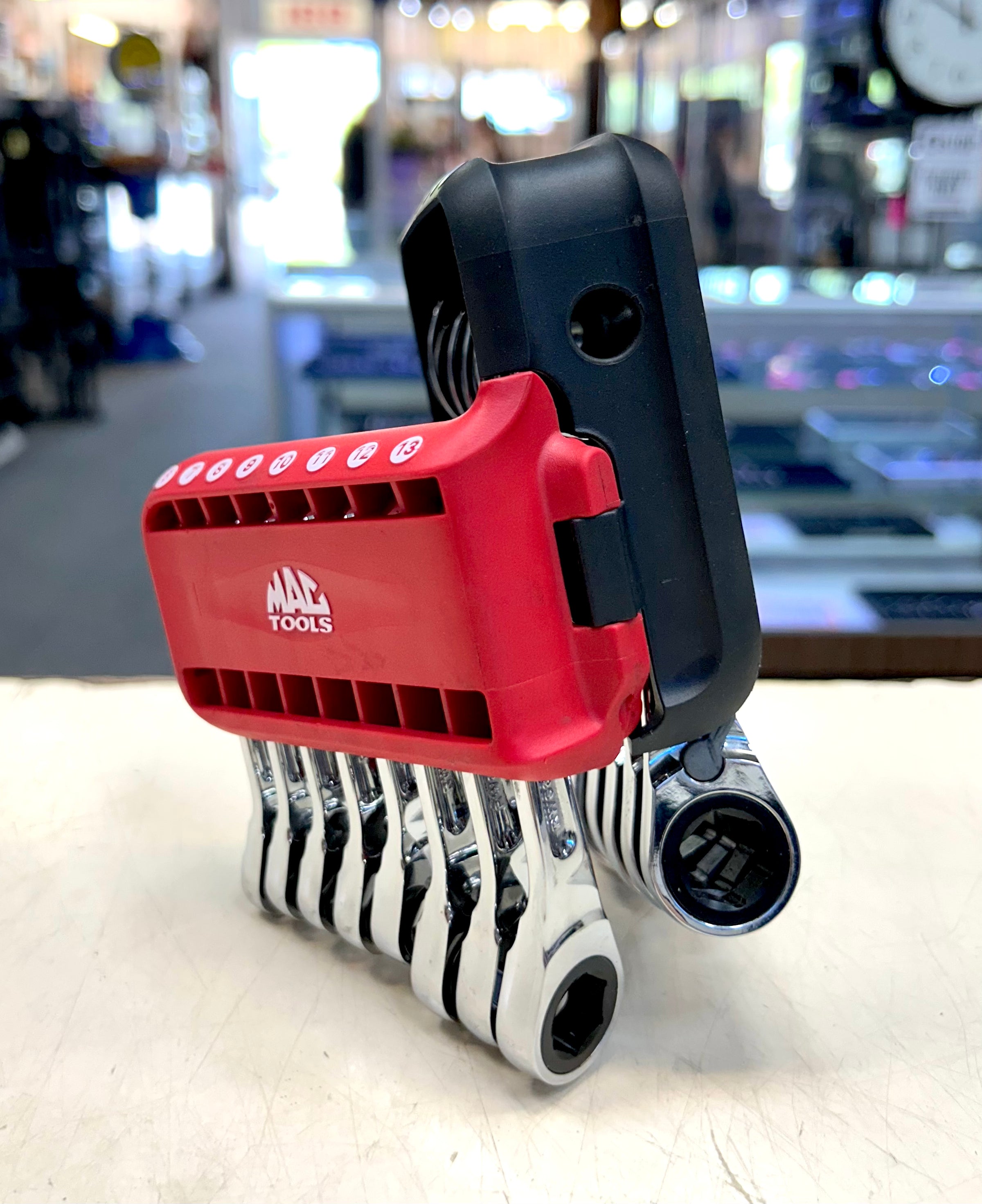 Red and black tool holder with MAC Tools branding on a blurred background