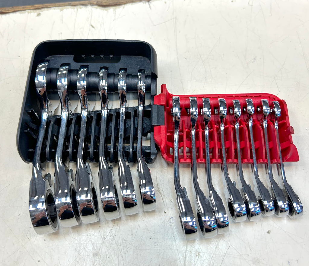 Set of wrenches in black and red tool holders on a white surface