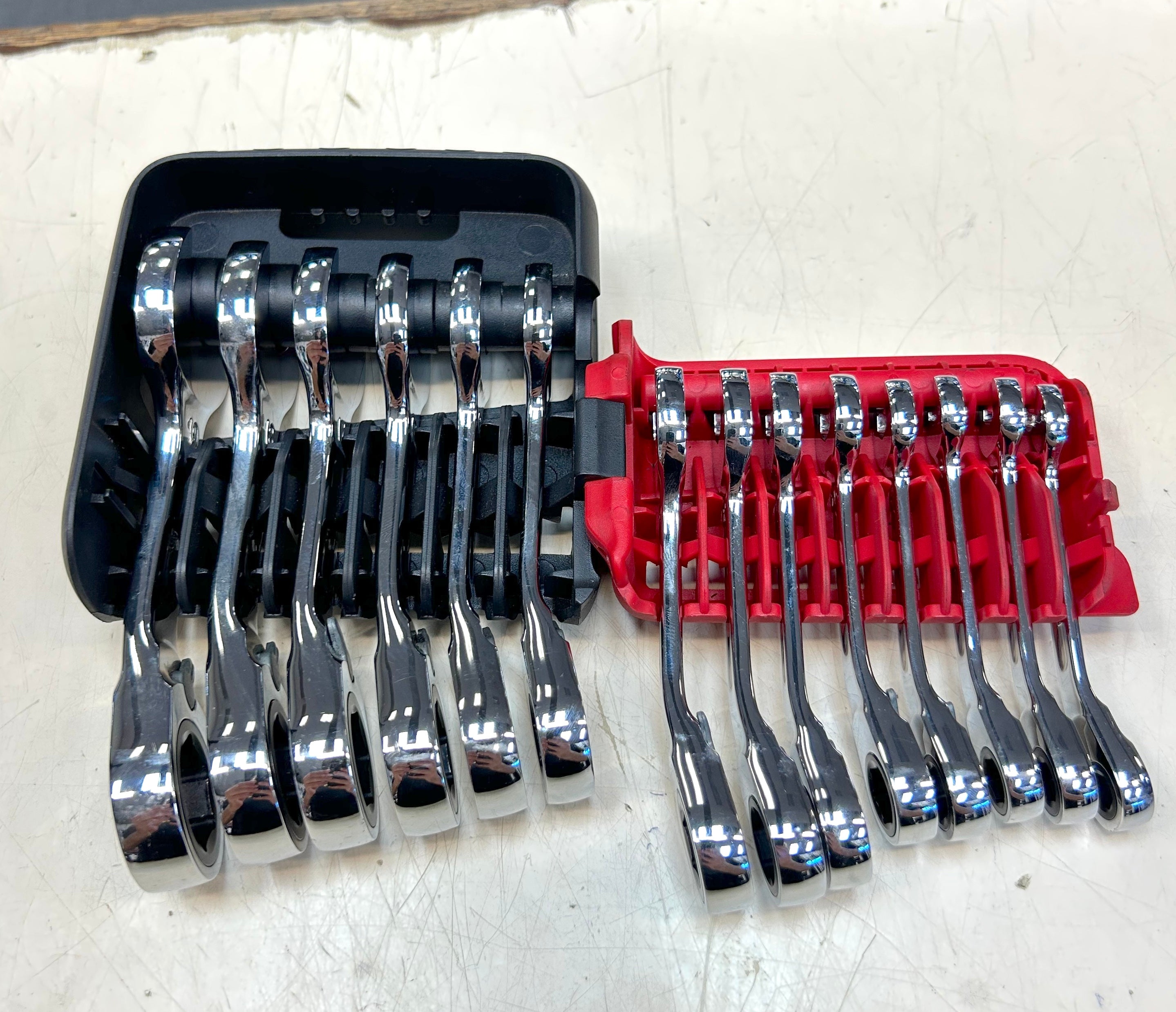Set of wrenches in black and red tool holders on a white surface