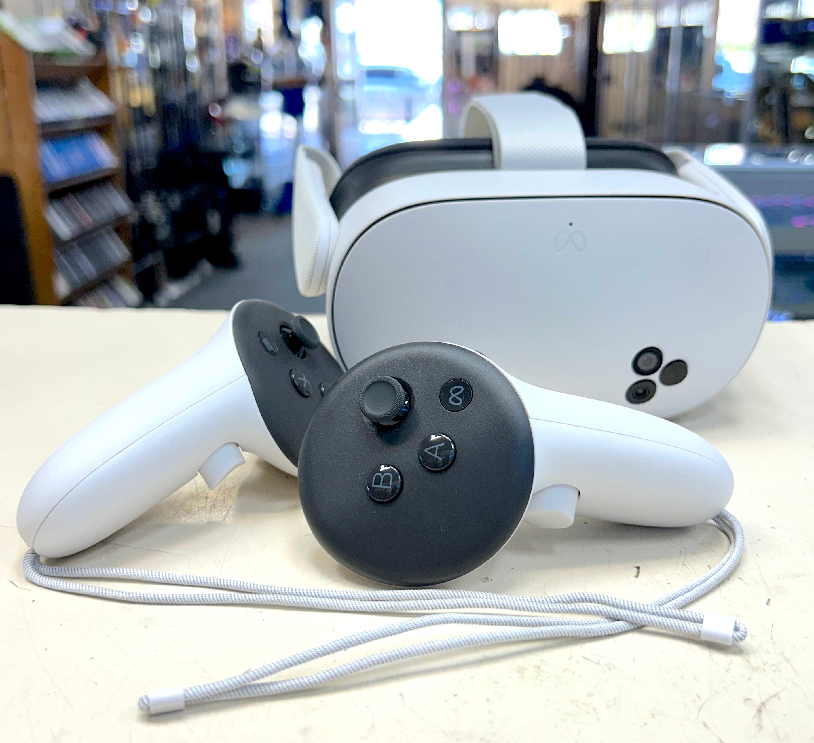 White VR headset and controllers on a table with a blurred store background