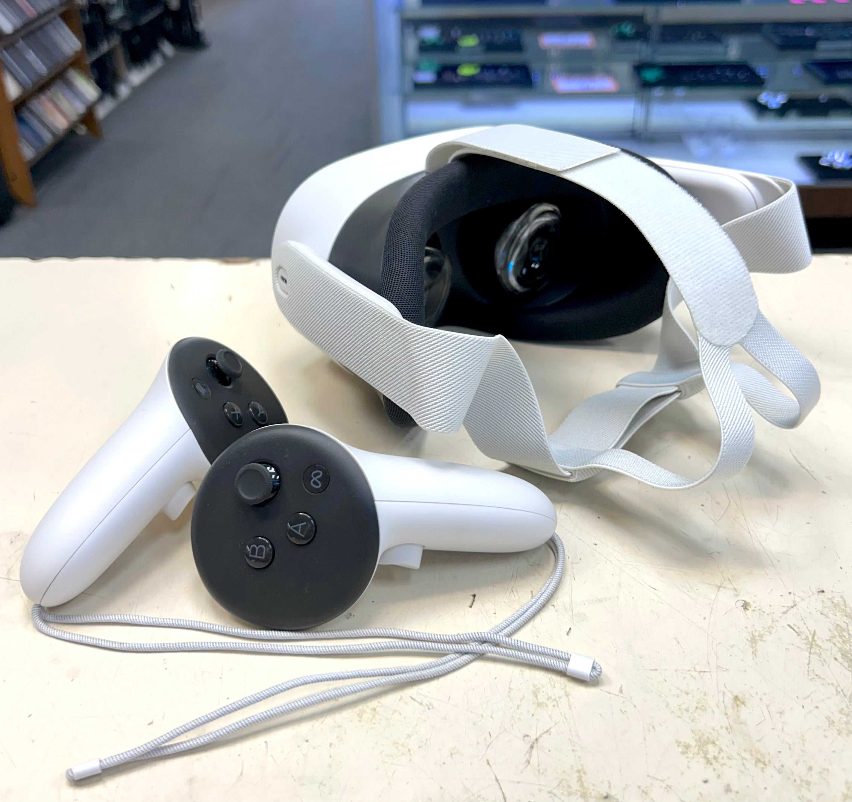 Meta Quest 3 VR headset and controllers on a table with a blurred background