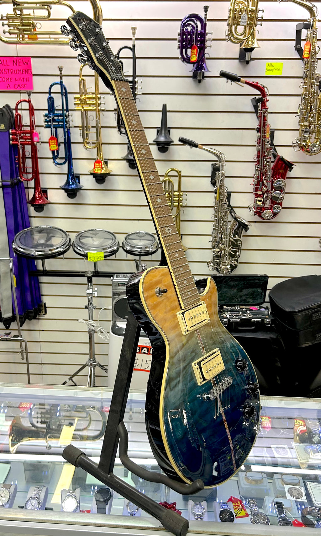Blue electric guitar on a stand in front of musical instruments in a store
