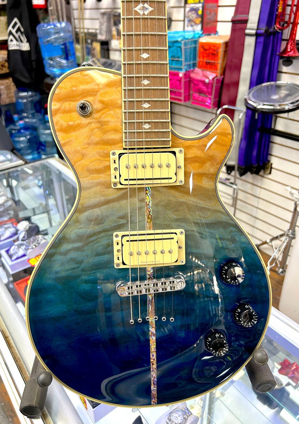 Michael Kelly Electric guitar with a blue and gold finish in a store setting