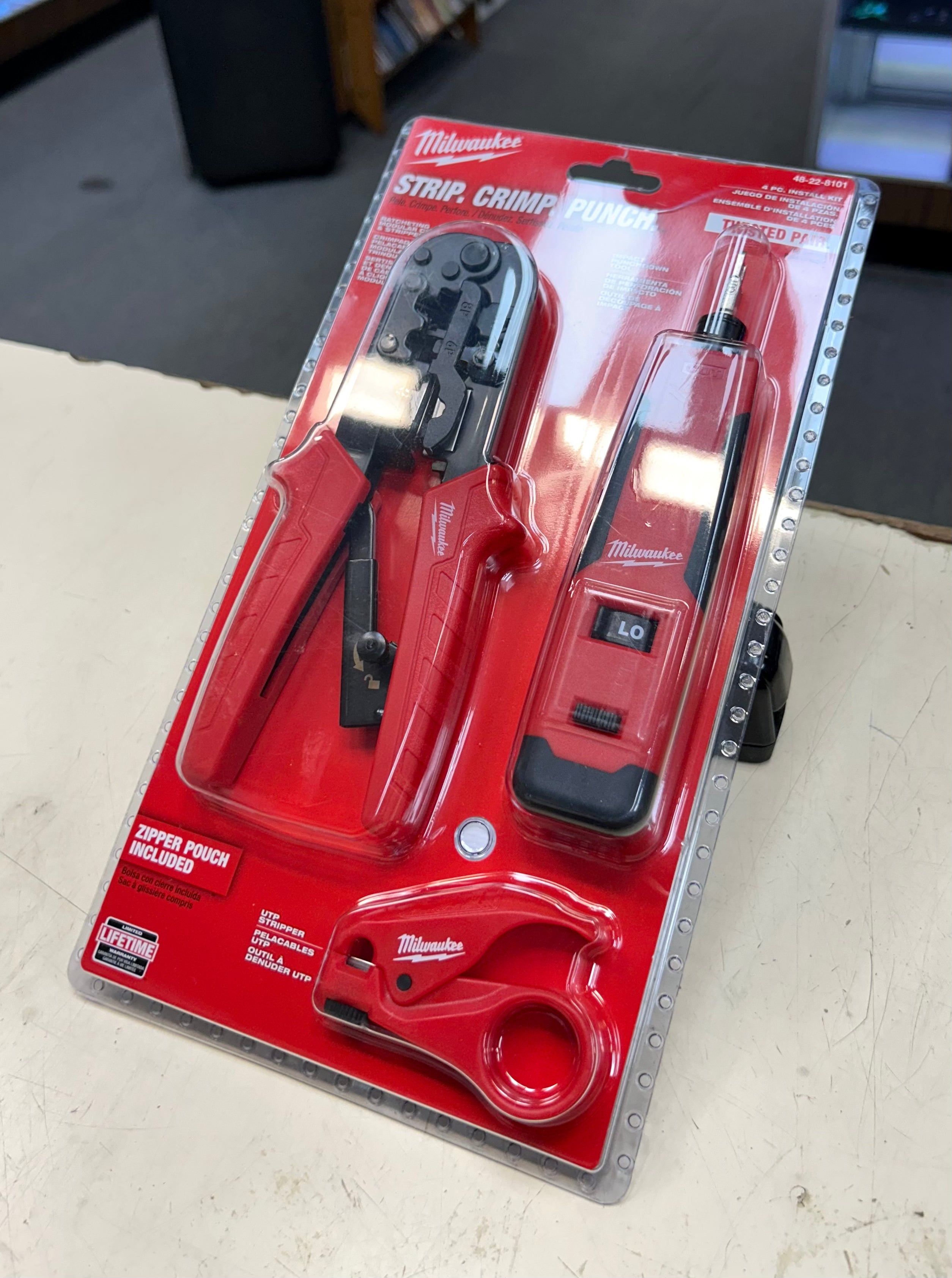 Milwaukee strip crimper tool set on a white surface