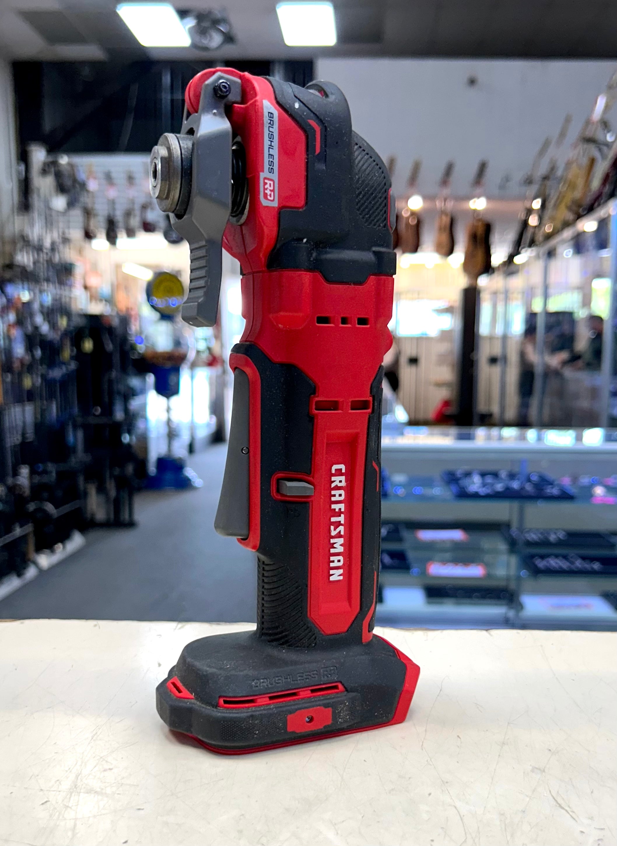 Red and black Craftsman power tool on a white surface with a blurred store background