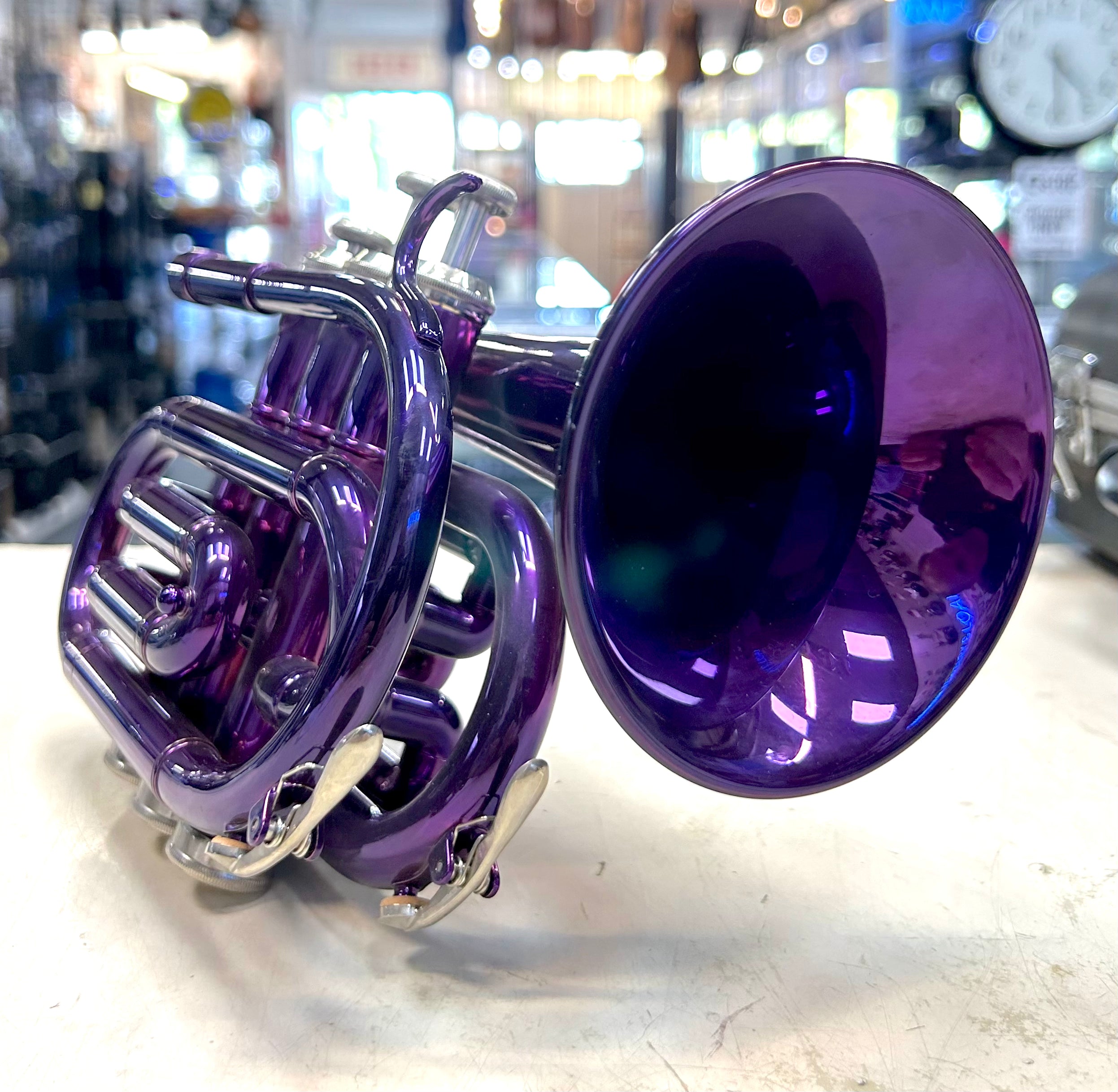 Purple pocket trumpet on a white surface with a blurred background
