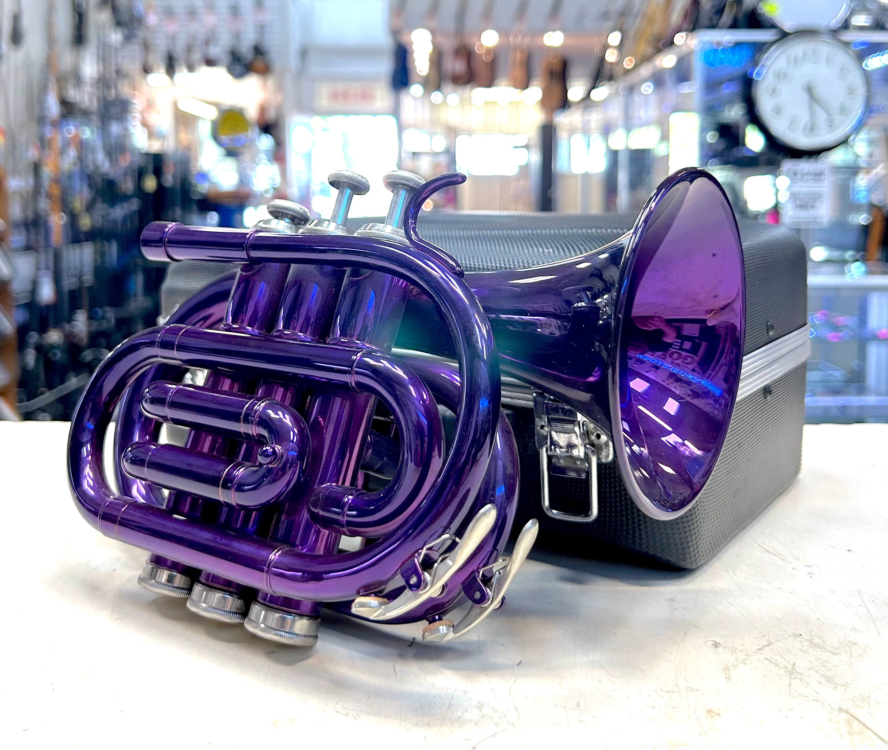 Purple pocket travel trumpet with case on a counter in a store setting