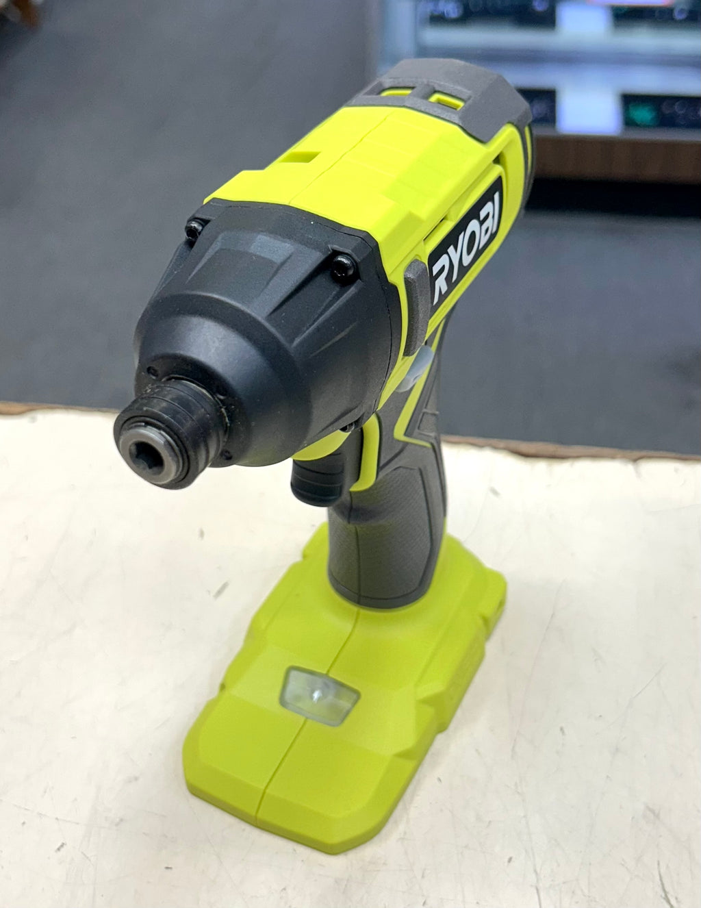 Ryobi power drill on a white surface with a blurred background