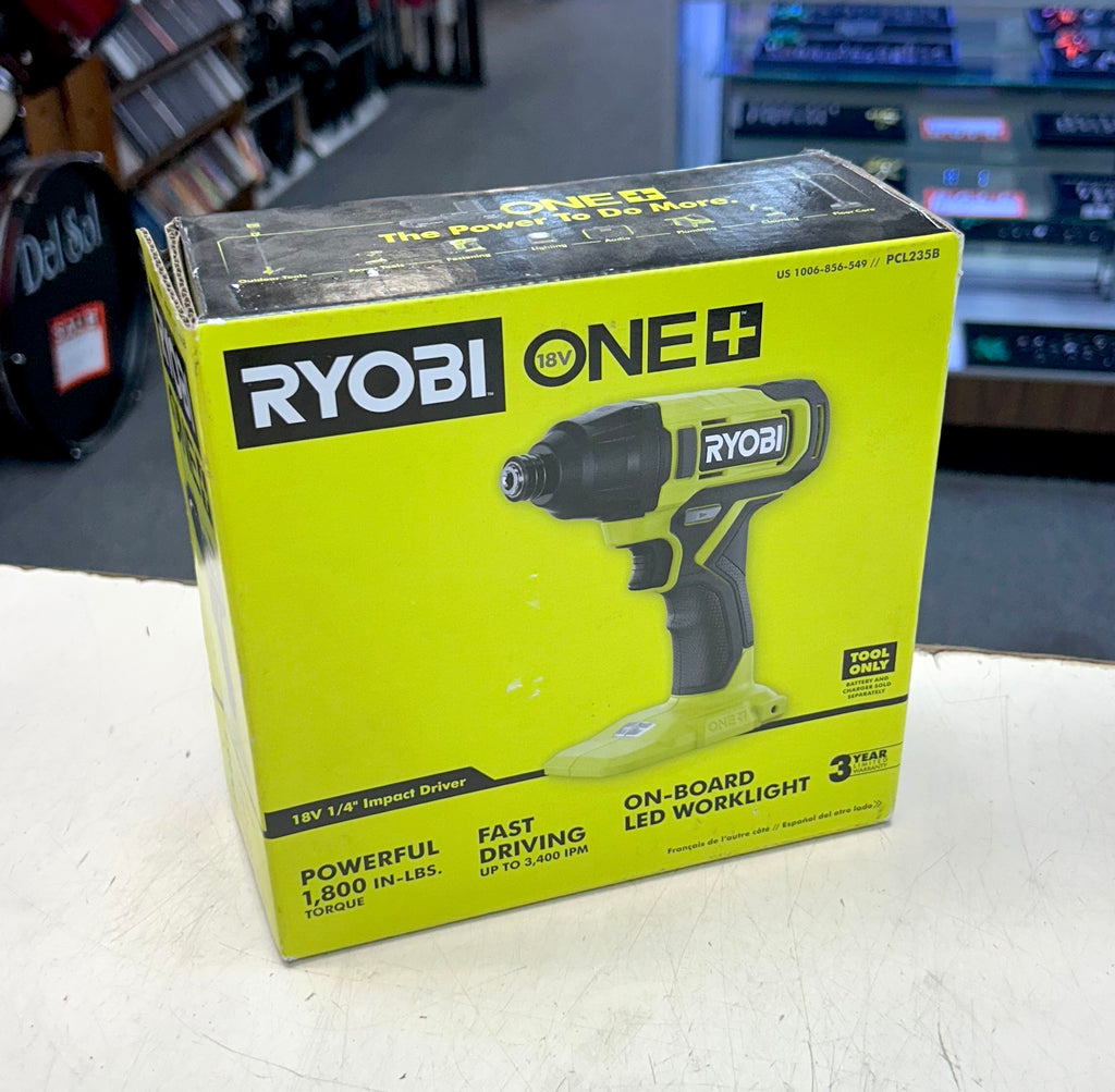 Ryobi One+ impact driver box on a white surface with a blurred background