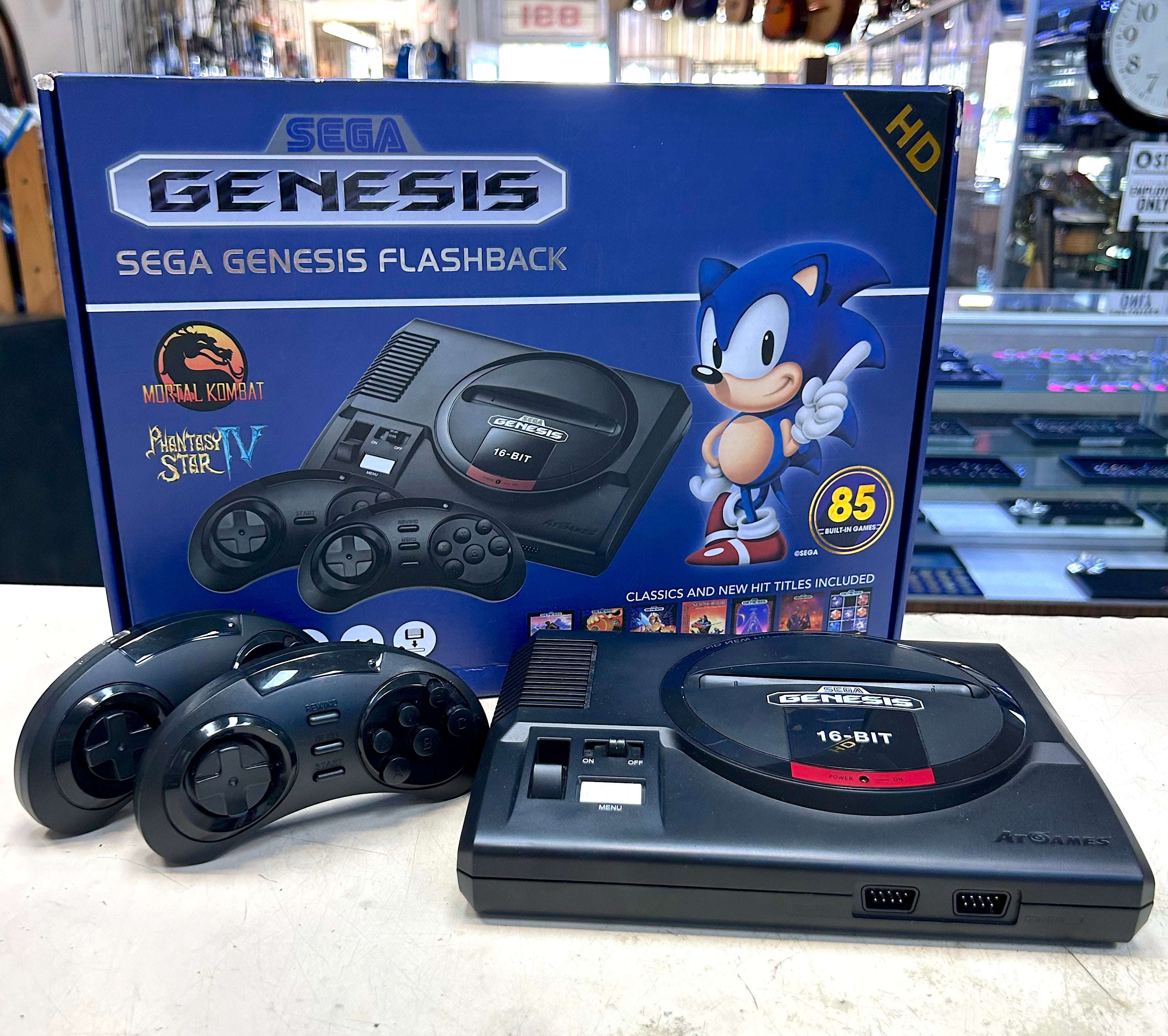 Sega Genesis Flashback console with controllers in front of a blue Sega Genesis box.