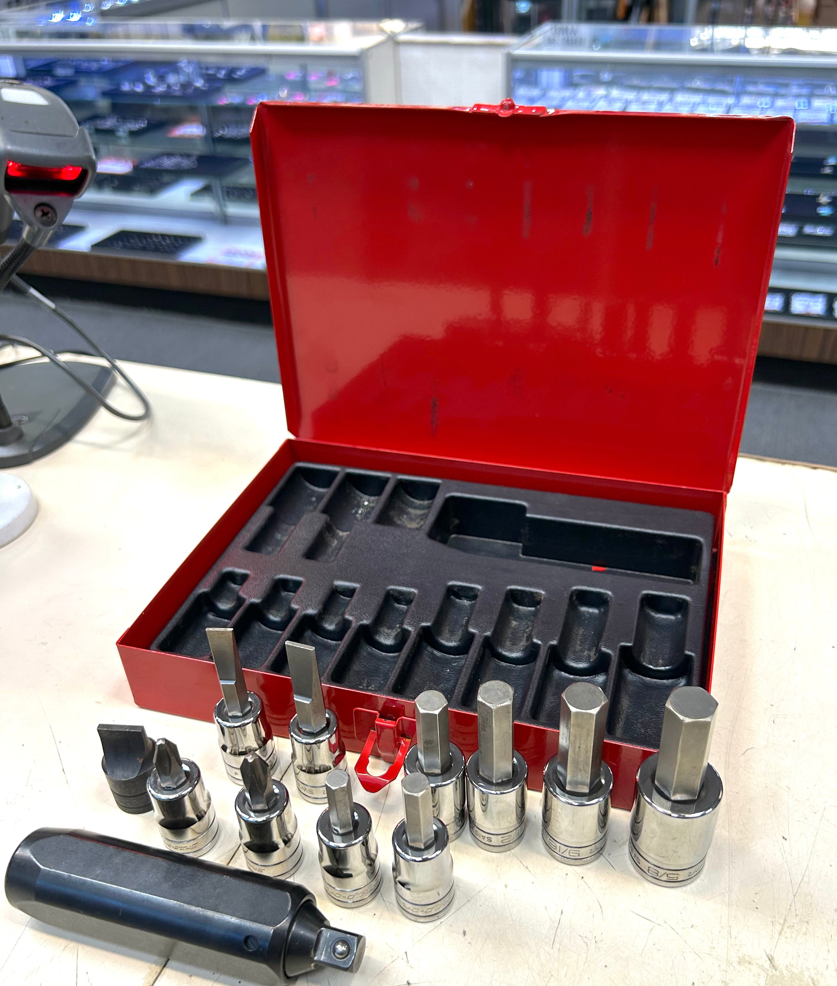 Set of socket wrenches in a red toolbox on a table.