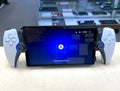 Handheld gaming console with screen displaying a logo on a white surface.