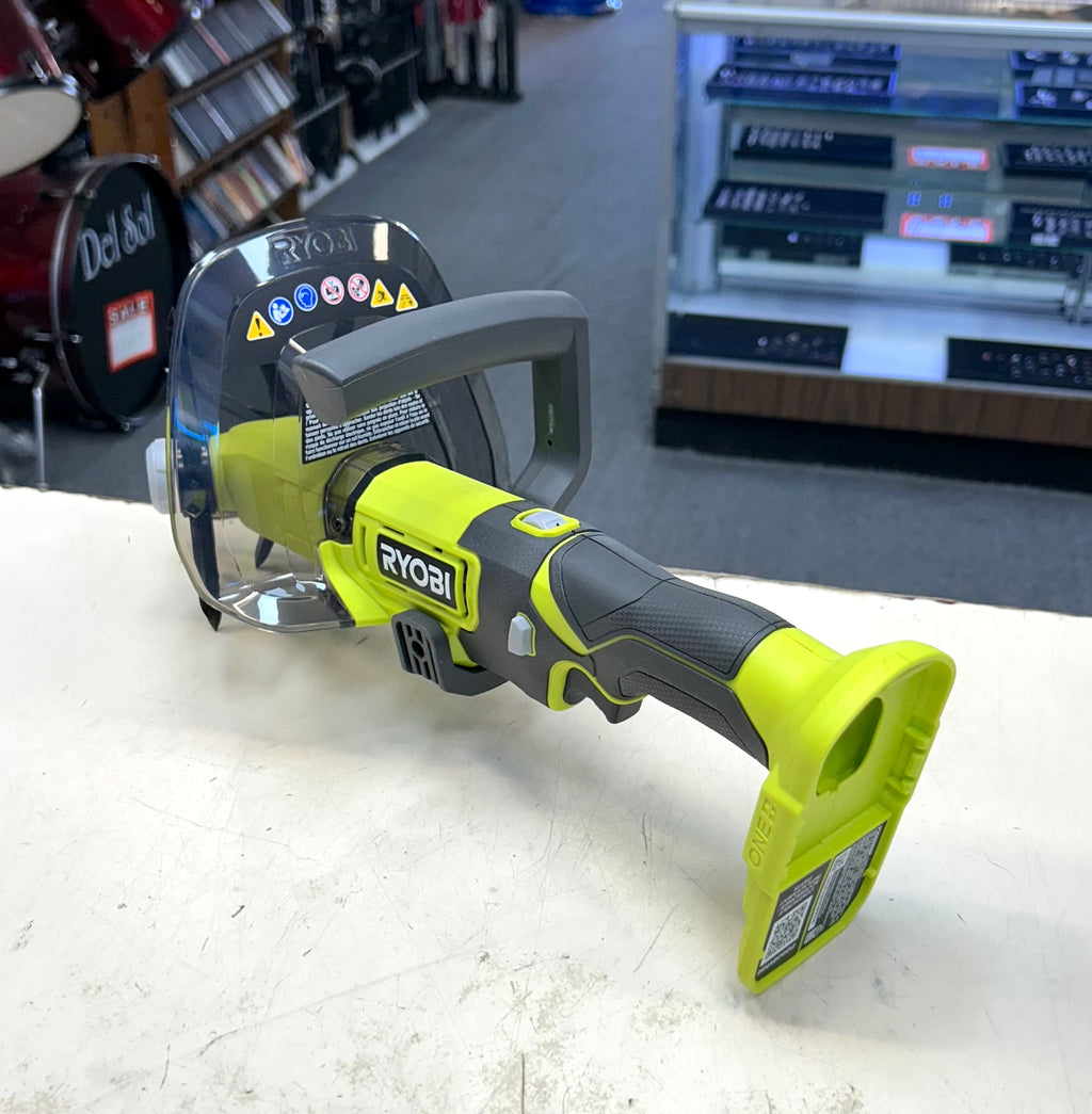 Ryobi power tool on a white surface with a store setting in the background