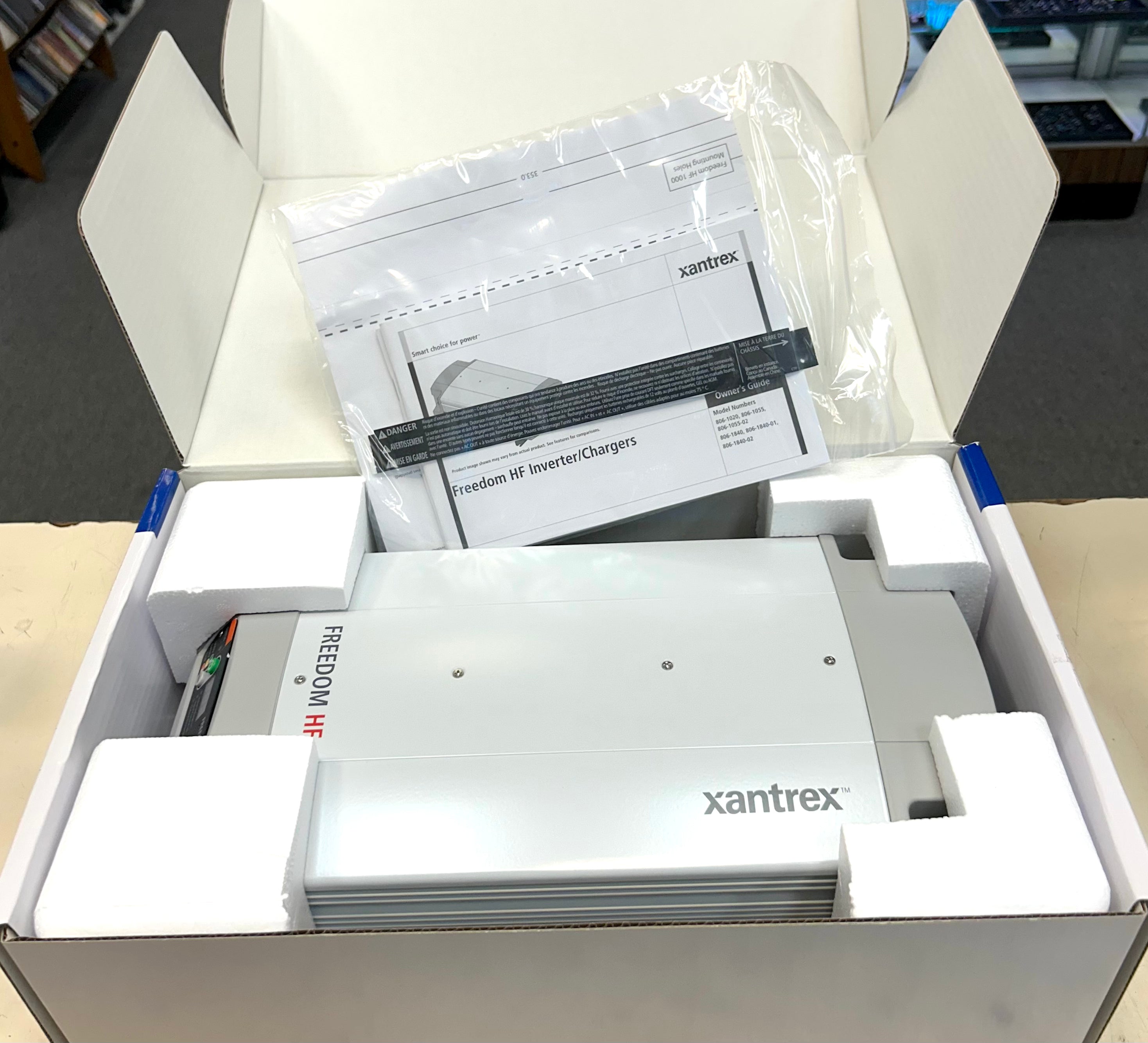 Xantrex product in an open box with documentation on a desk.